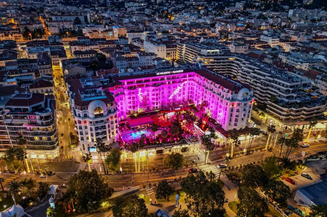 A seafront palace hotel lit up at night on the French Riviera