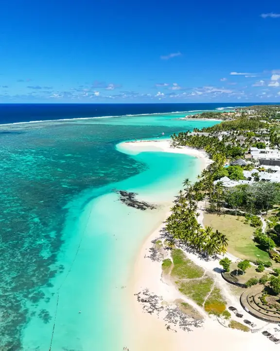 A white sand beach and turquoise water seen from above
