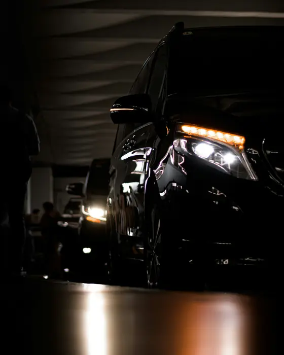 A black chauffeur-driven car waiting at night